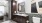 Large well lit bathroom with dark wood cabinets and custom backsplash.